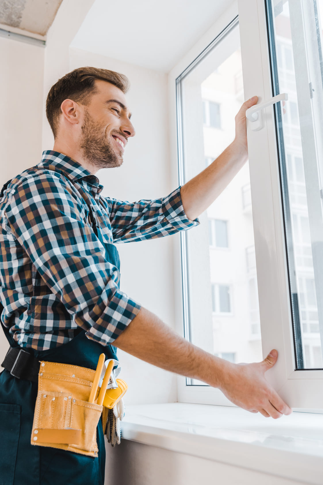 cheerful-handyman-with-tool-belt-smiling-while-ope-2024-11-19-05-20-30-utc-2